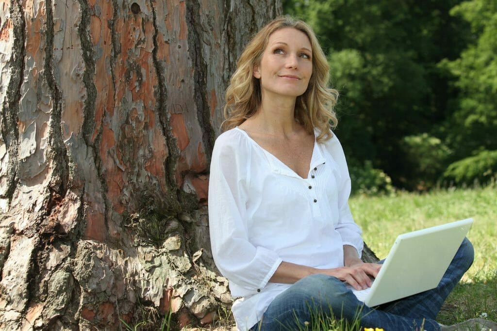 bigstock Young woman sat by tree with l 25834643 1